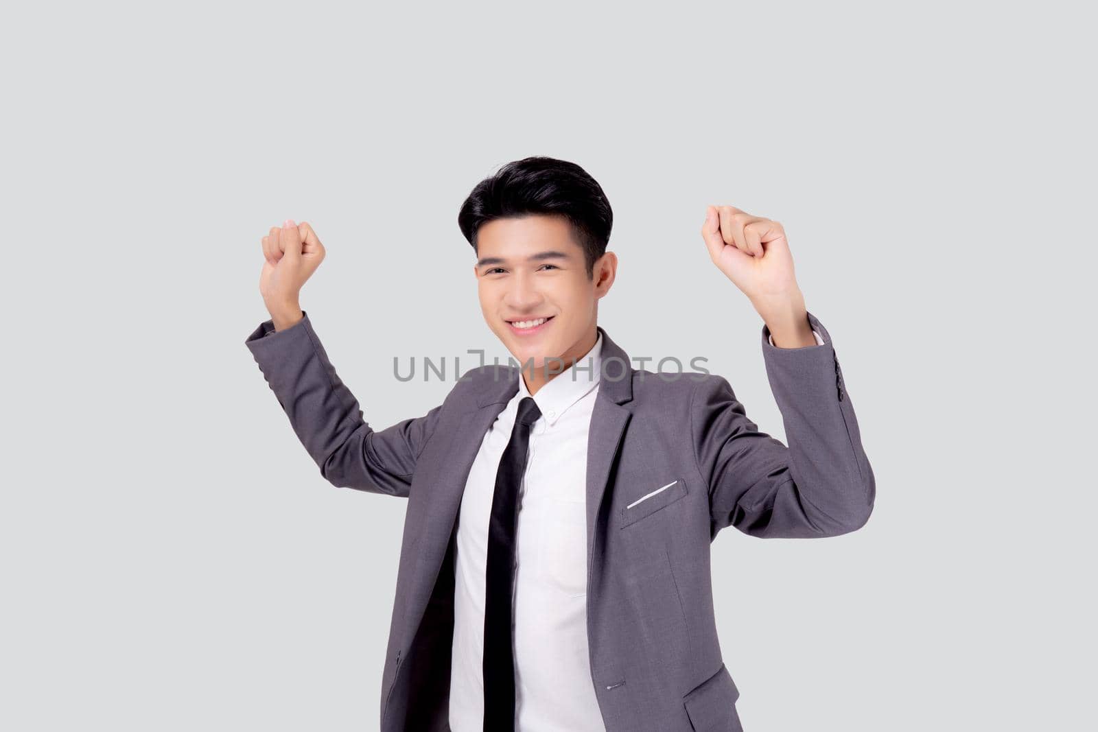 Portrait businessman in suit standing with win success isolated on white background, young asian business man is manager or executive having confident and excited is positive, expression and emotion. by nnudoo