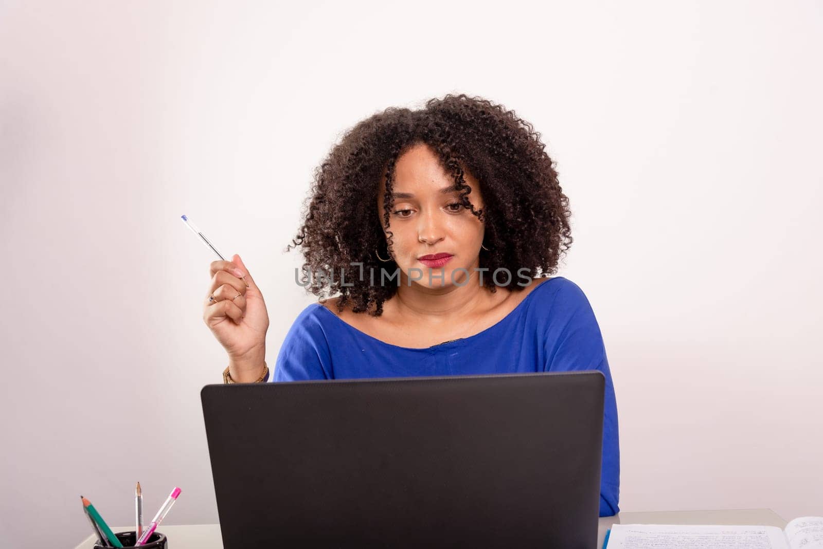 Young pretty female manager working in her space. Using laptop.