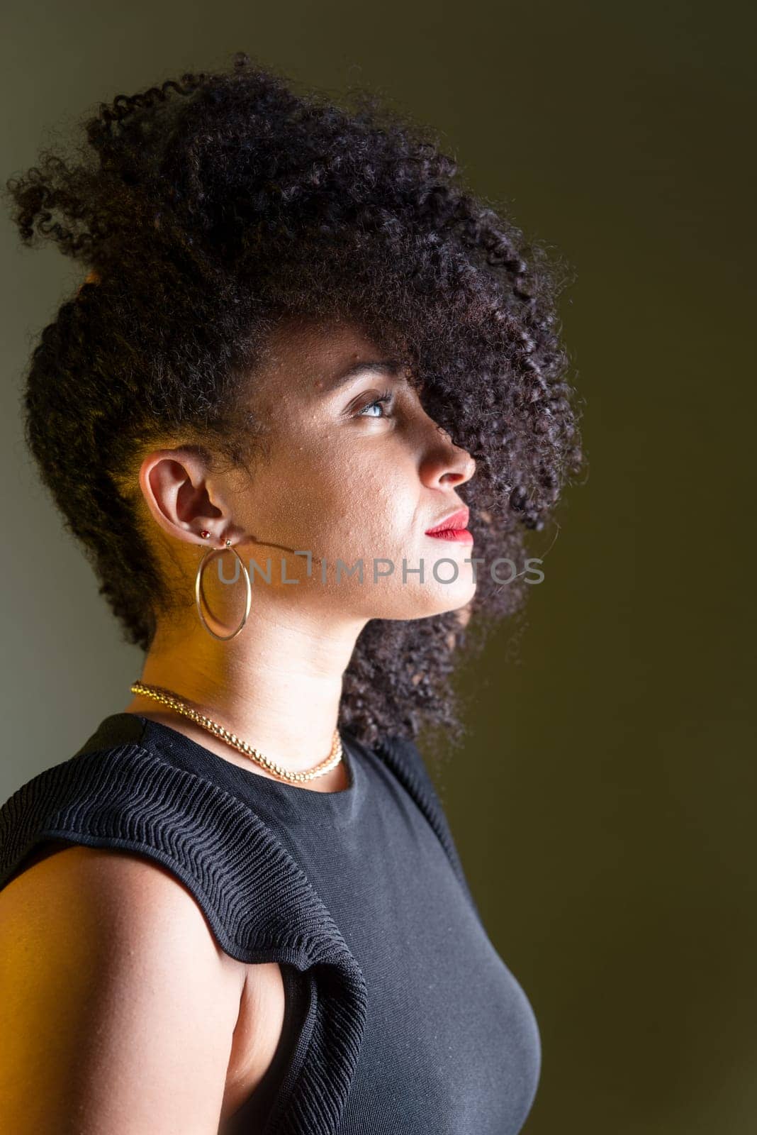 Beautiful young woman in profile wearing black clothing, with hair in her face.  by ThalesAntonio