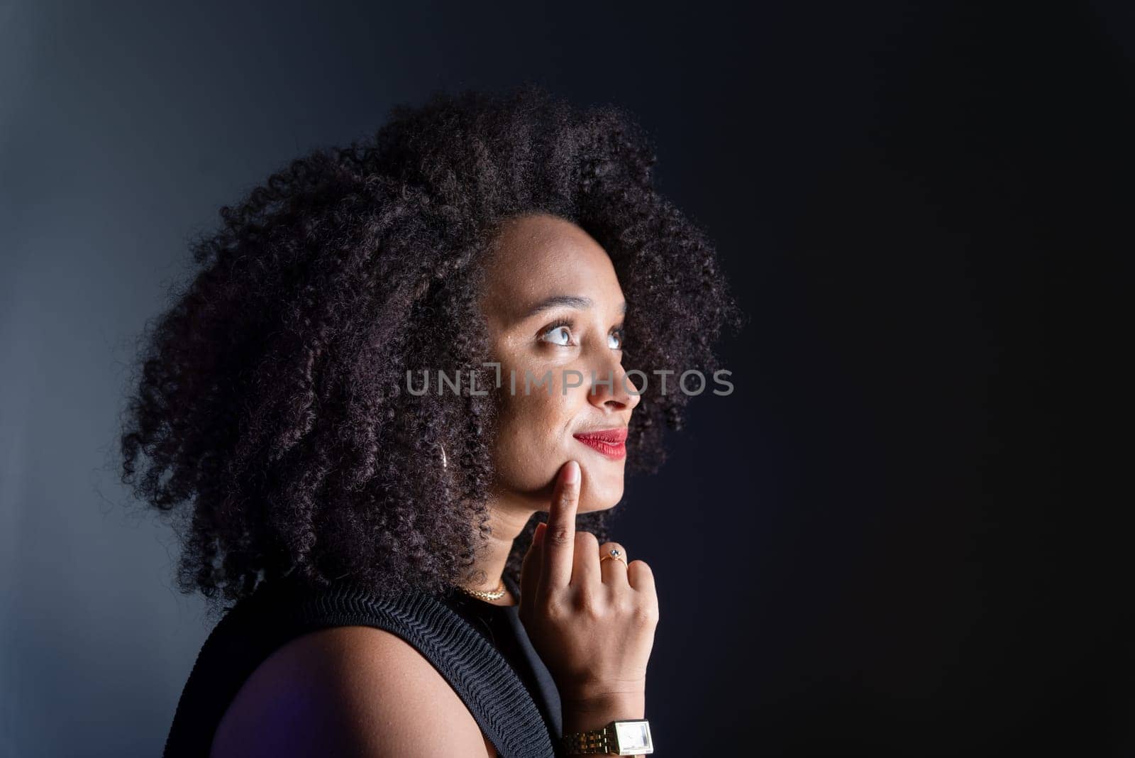 Beautiful young woman relaxed and thoughtful against gray background. studio portrait