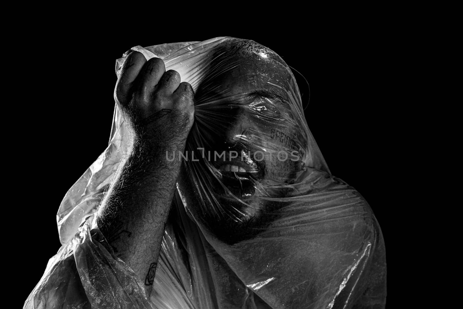 Man with plastic bag over his head, suffocated. Black and white shot. pain expression.