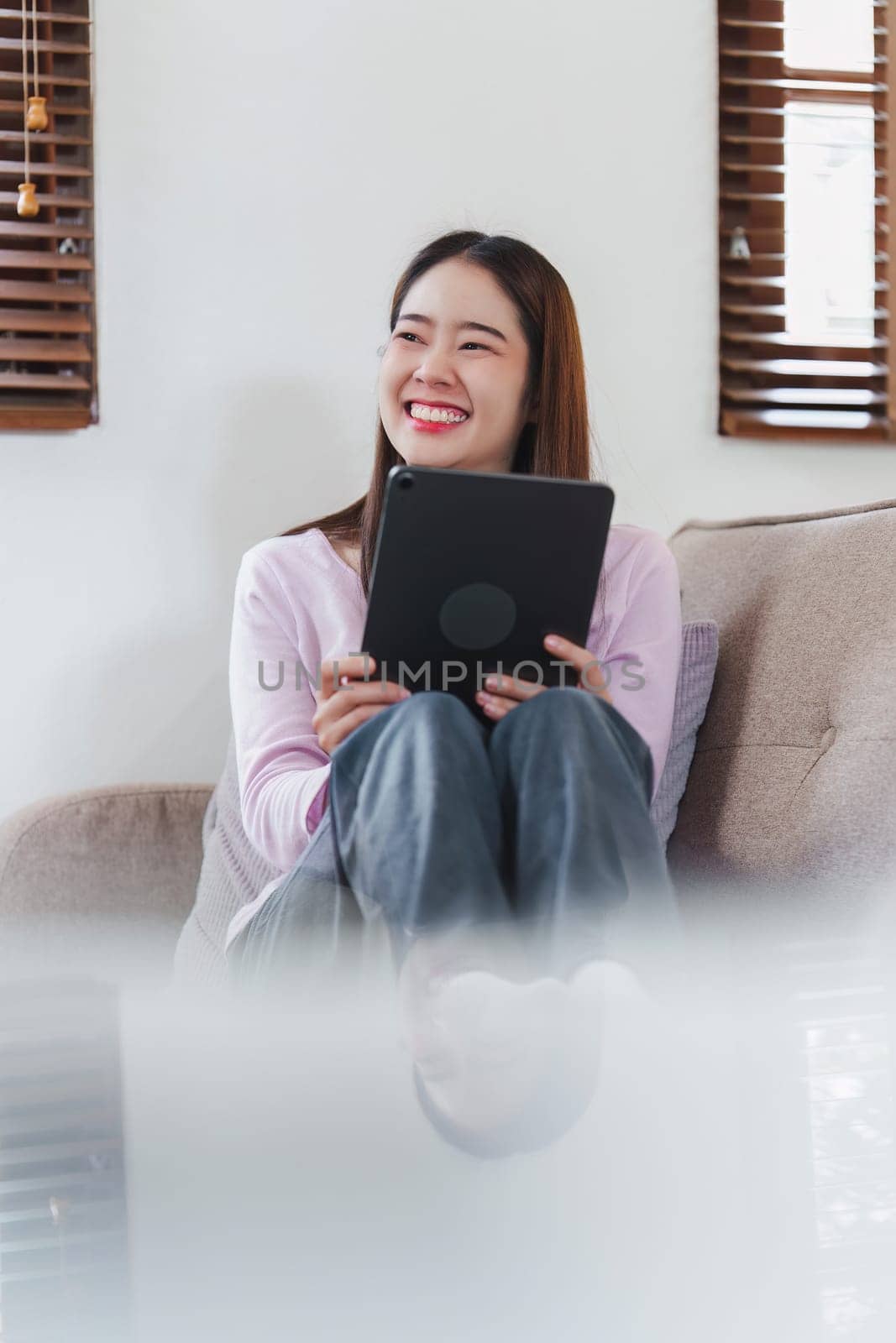 Attractive Asian woman resting comfortable living room and using digital tablet, Relax, Sofa, Lifestyle.