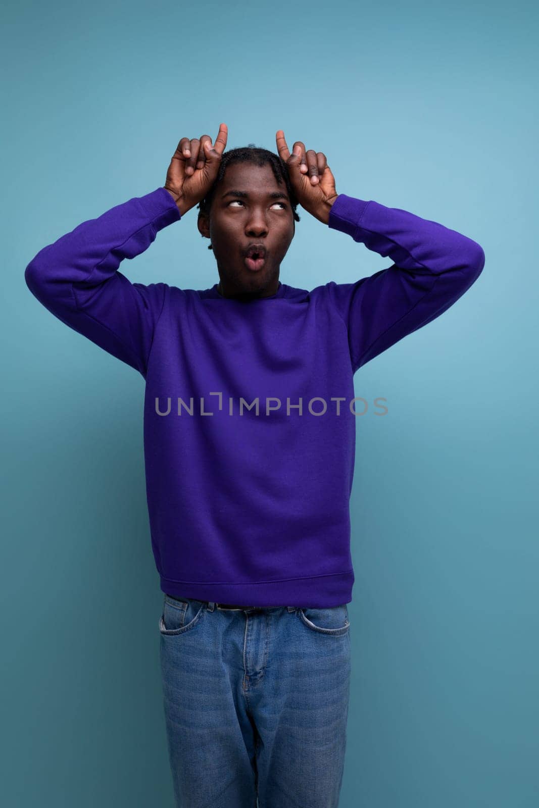 black american young guy with dreadlocks makes a face.