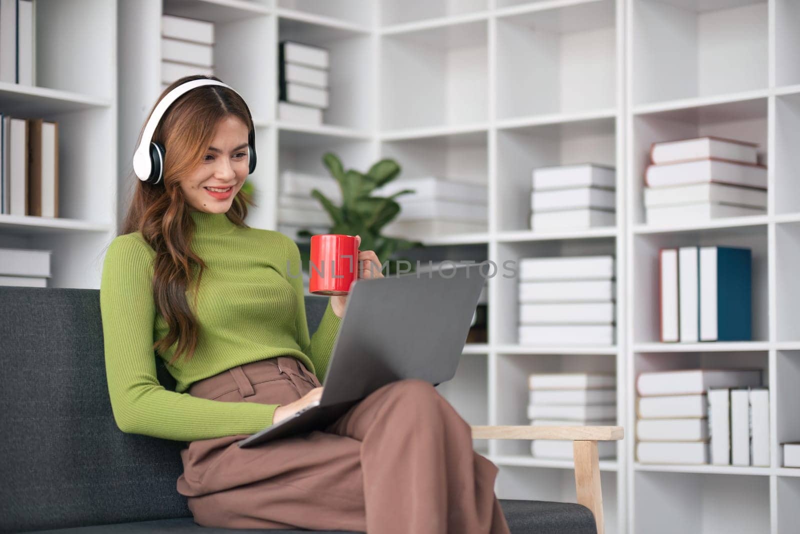 happy beautiful asian woman relaxing using of laptop working with drinking coffee in the morning at home concept by nateemee