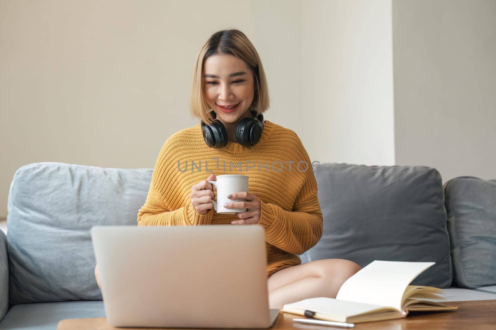 happy beautiful asian woman relaxing using of laptop working with drinking coffee in the morning at home concept by nateemee