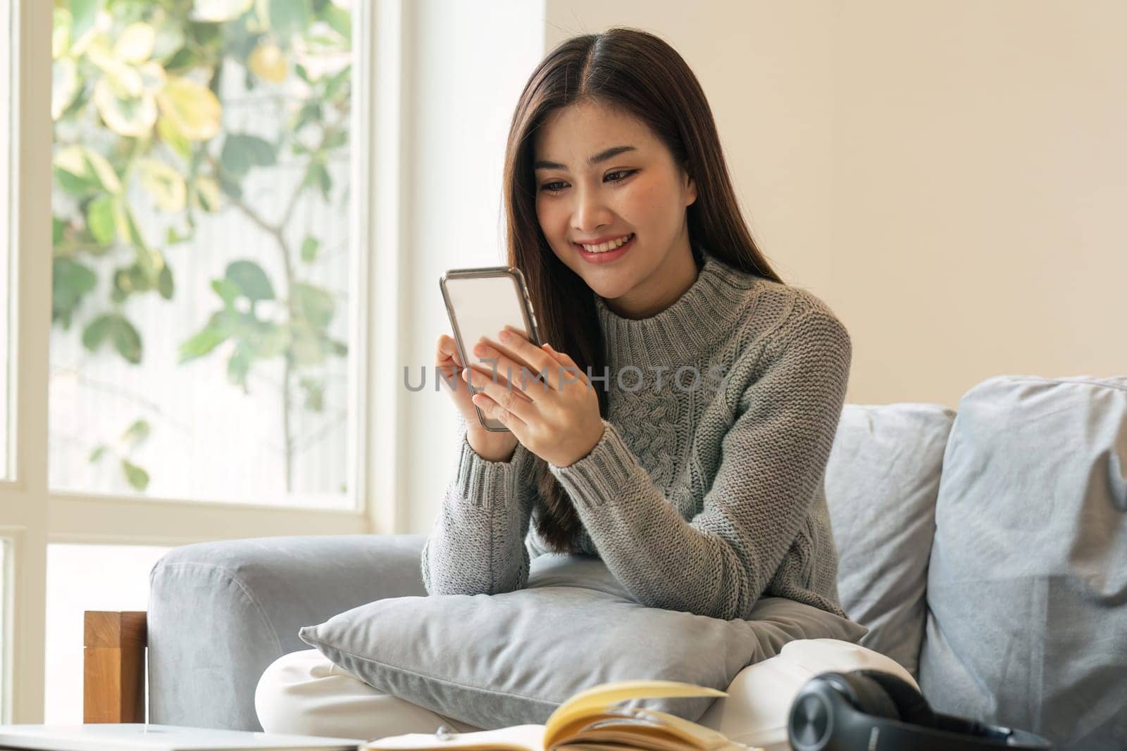 Happy teen girl holding cell phone using smartphone device at home. subscribing new social media, buying in internet, ordering products online in apps.