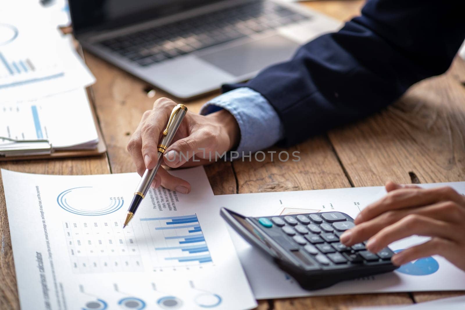 Closed up young business man read write doing report figure paper chart, professional accountant calculating annual balance cash flow money report finance at office. High quality photo