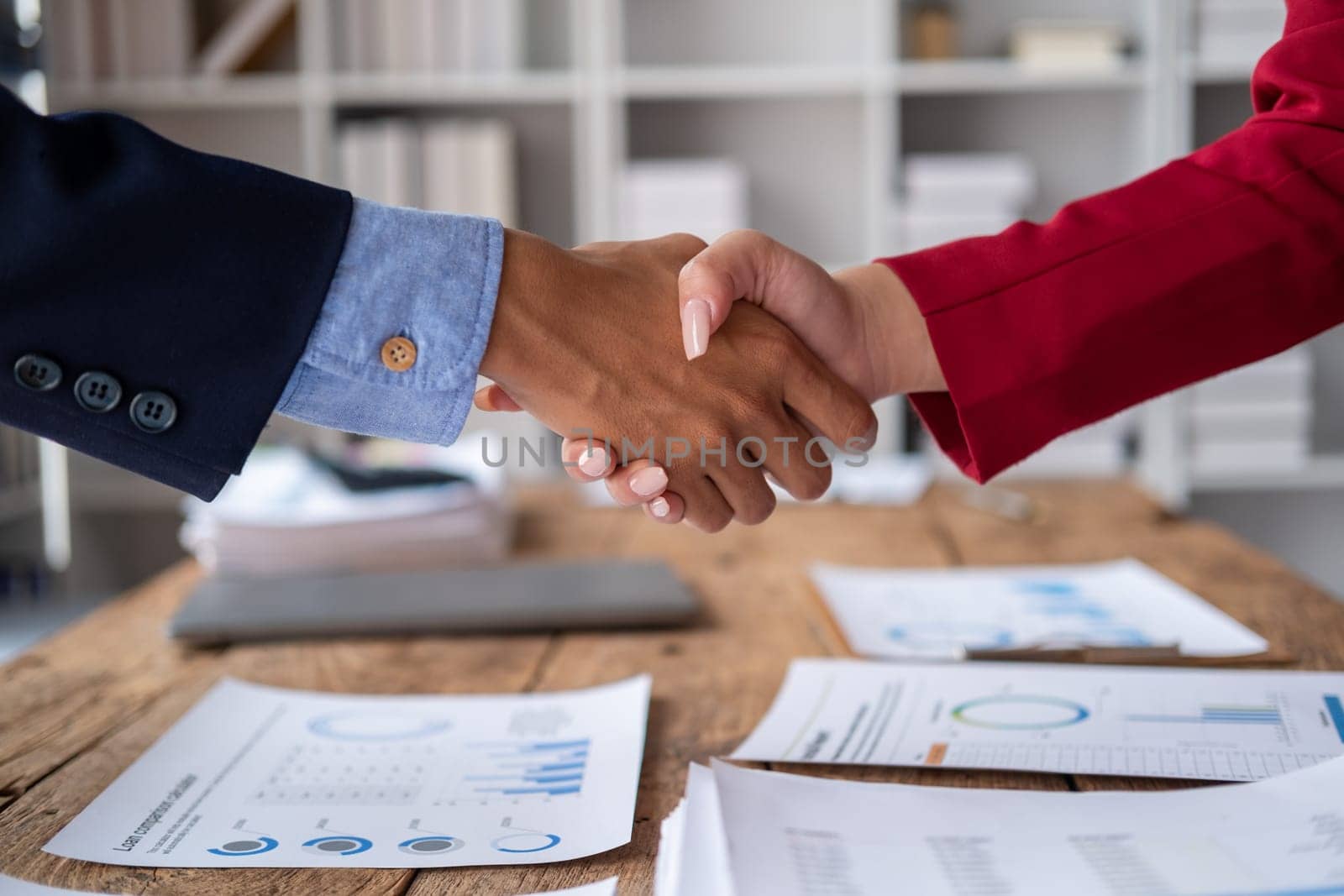 business man and woman are shaking hand in office, Business handshaking, businessmen shake hand after the meeting was successful. High quality photo