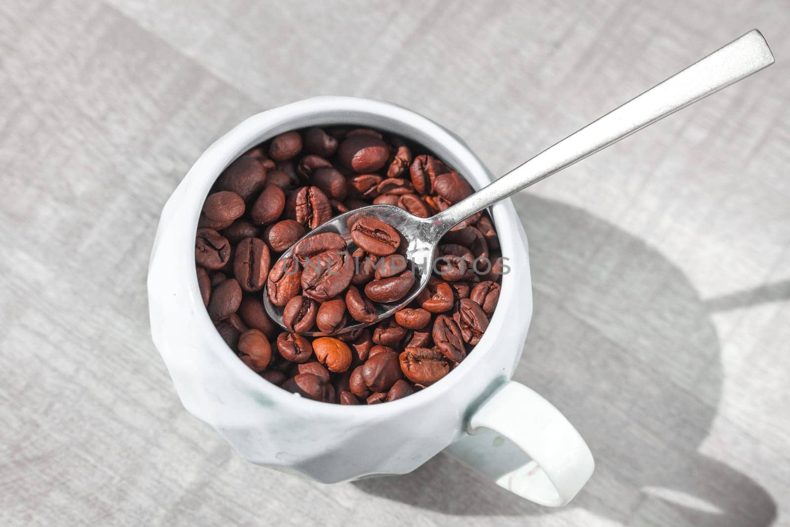 coffee beans in cup on the plate with spoon on the tabe