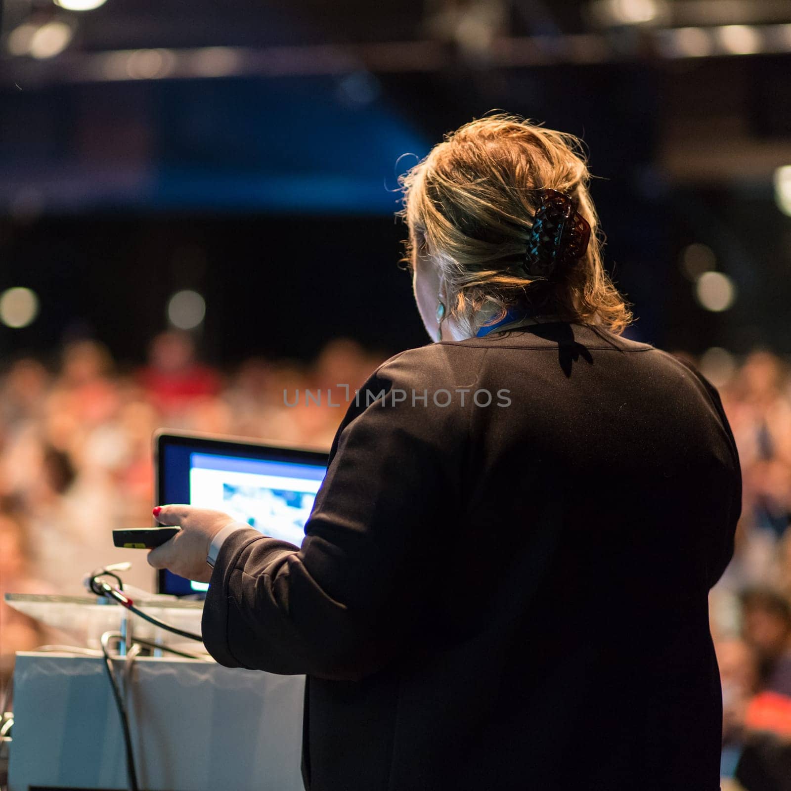 Female public speaker giving talk at Business Event. by kasto