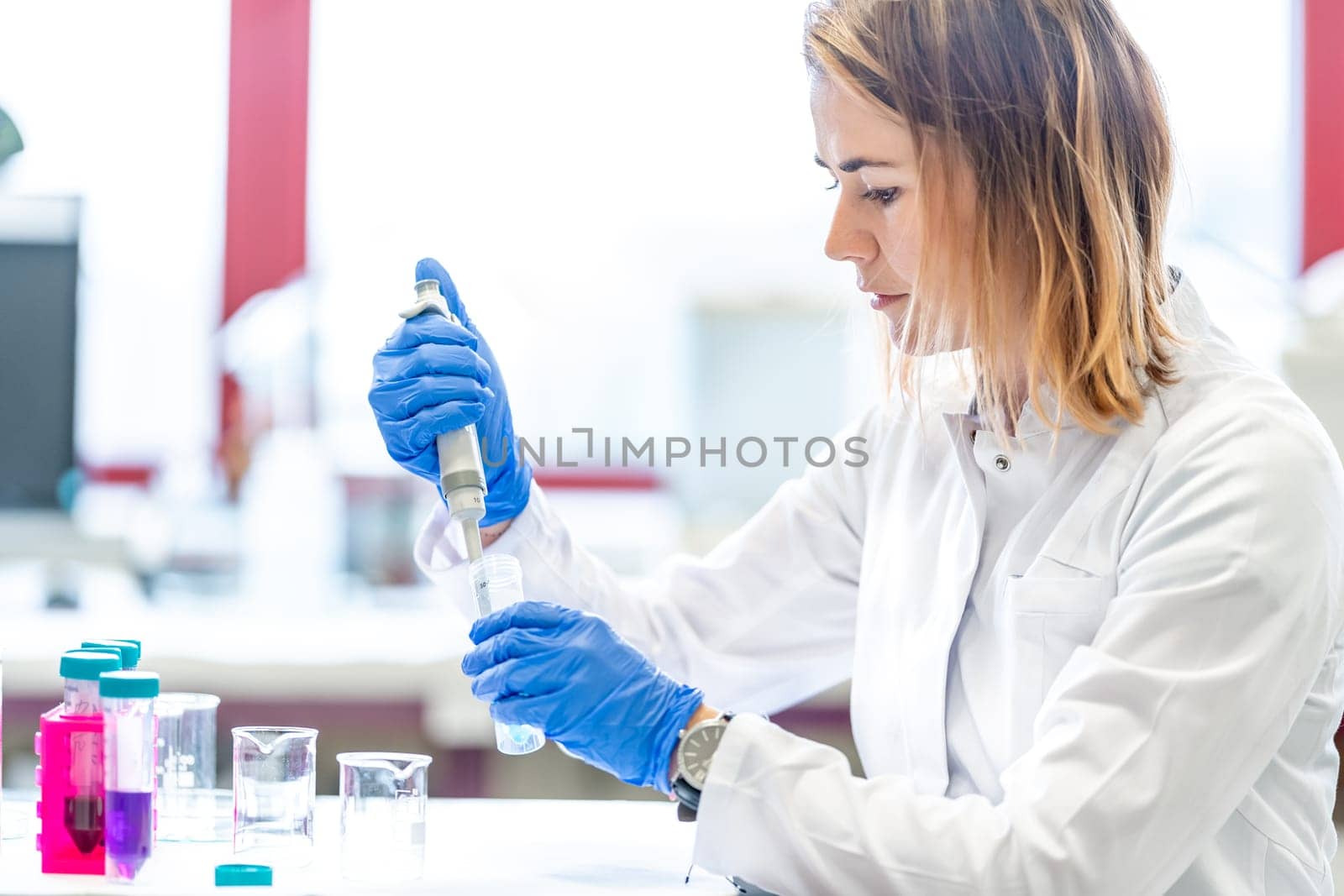 mixing of chemical substances by a young female scientist in a university research laboratory. development of new drugs and products.