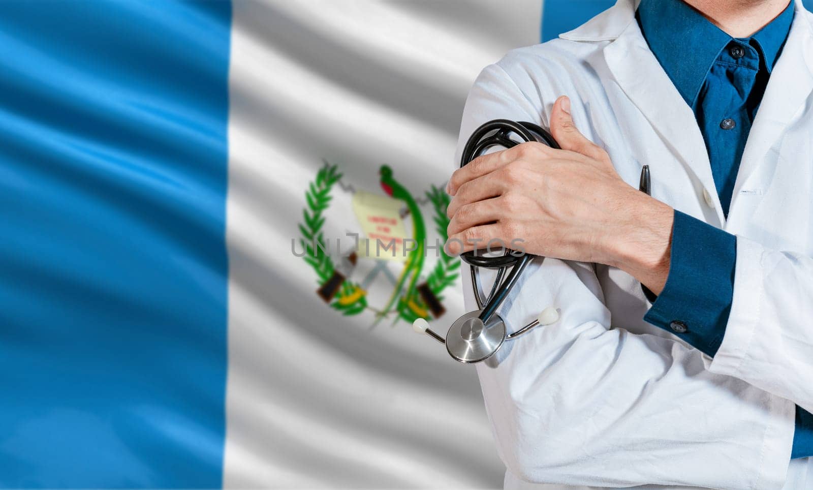 Doctor with stethoscope on guatemala flag. Health and care with the flag of Guatemala. Guatemala national health concept, Doctor arm with stethoscope on Guatemala flag by isaiphoto