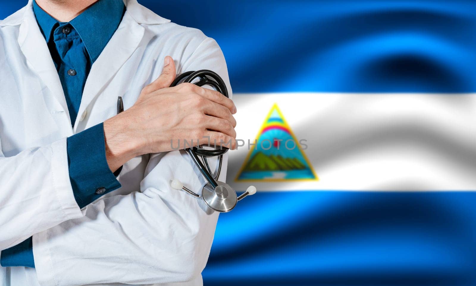Doctor with stethoscope on Nicaragua flag. Health and care with the flag of Nicaragua. Nicaragua national health concept, Doctor arm holding stethoscope on nicaragua flag by isaiphoto