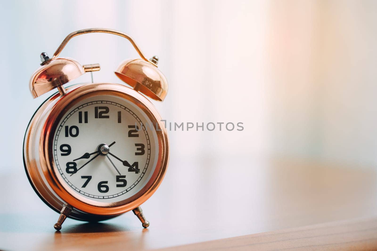 Vintage bell alarm clock on the table for the concept of time management.