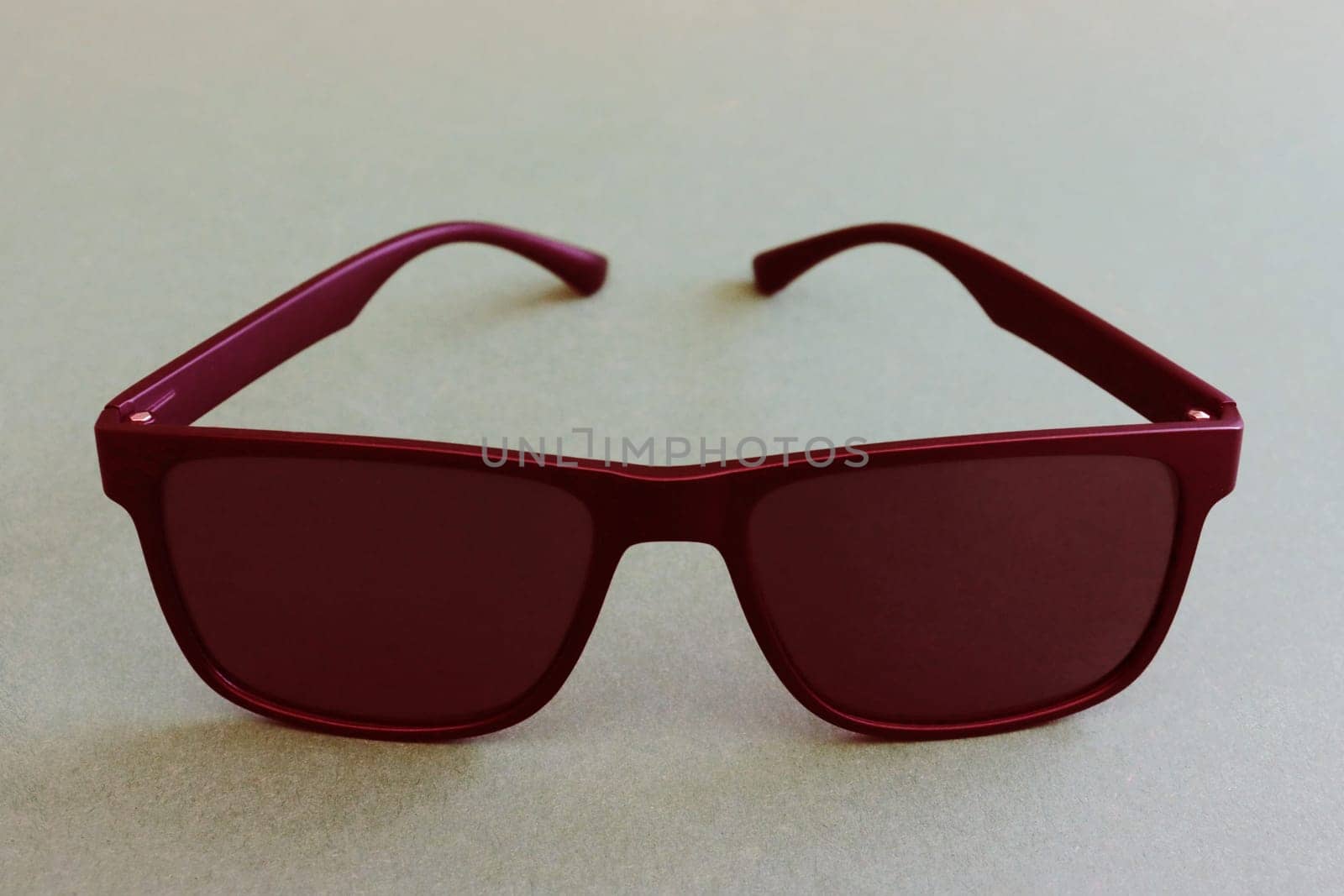 Fashionable men's red sunglasses close-up on a paper background. Abstract image of glasses. Special icons.....