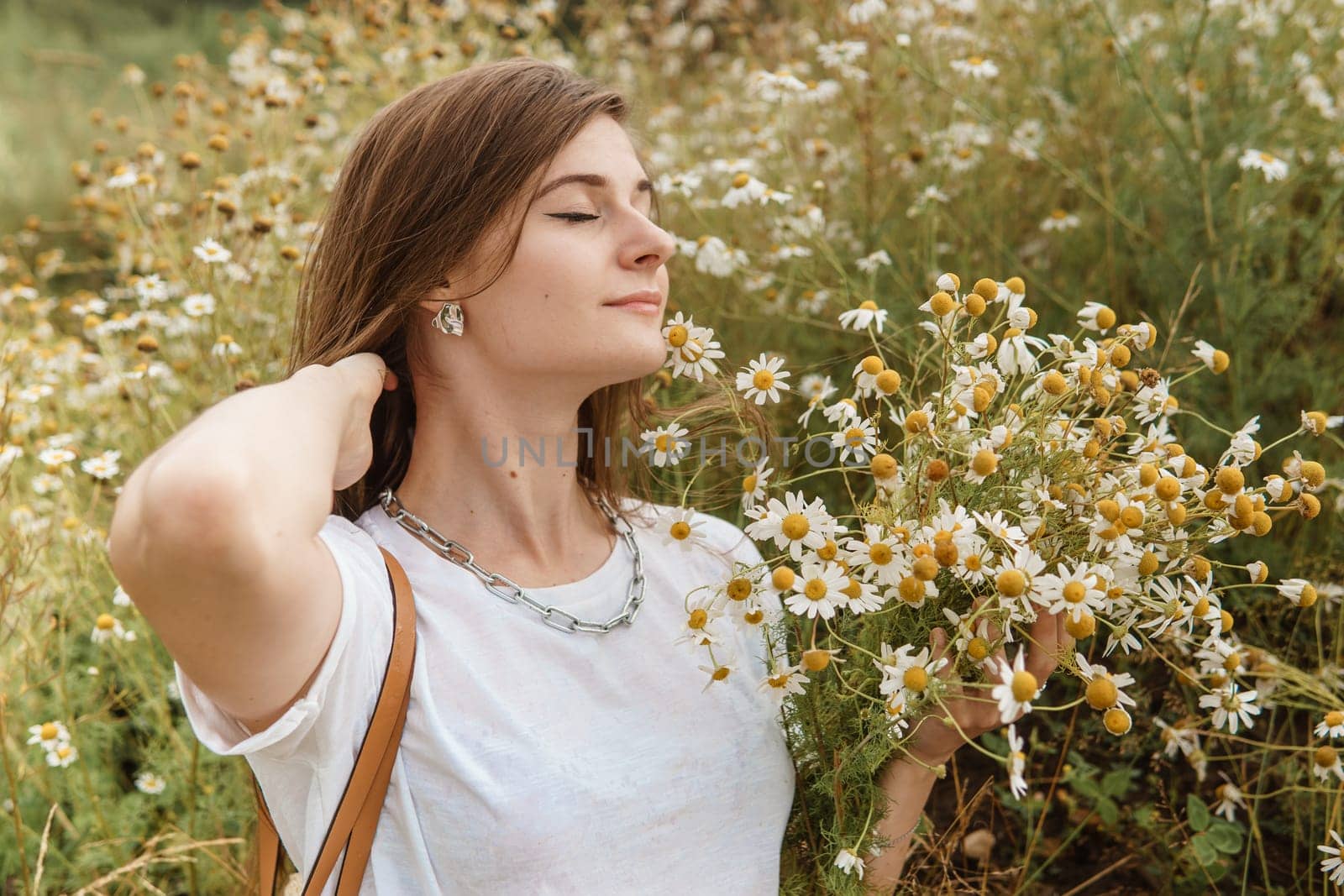 Beautiful young woman in nature with a bouquet of daisies. Field daisies, field of flowers. by Annu1tochka