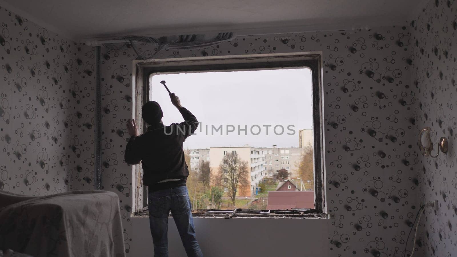 An employee removes an old wooden window