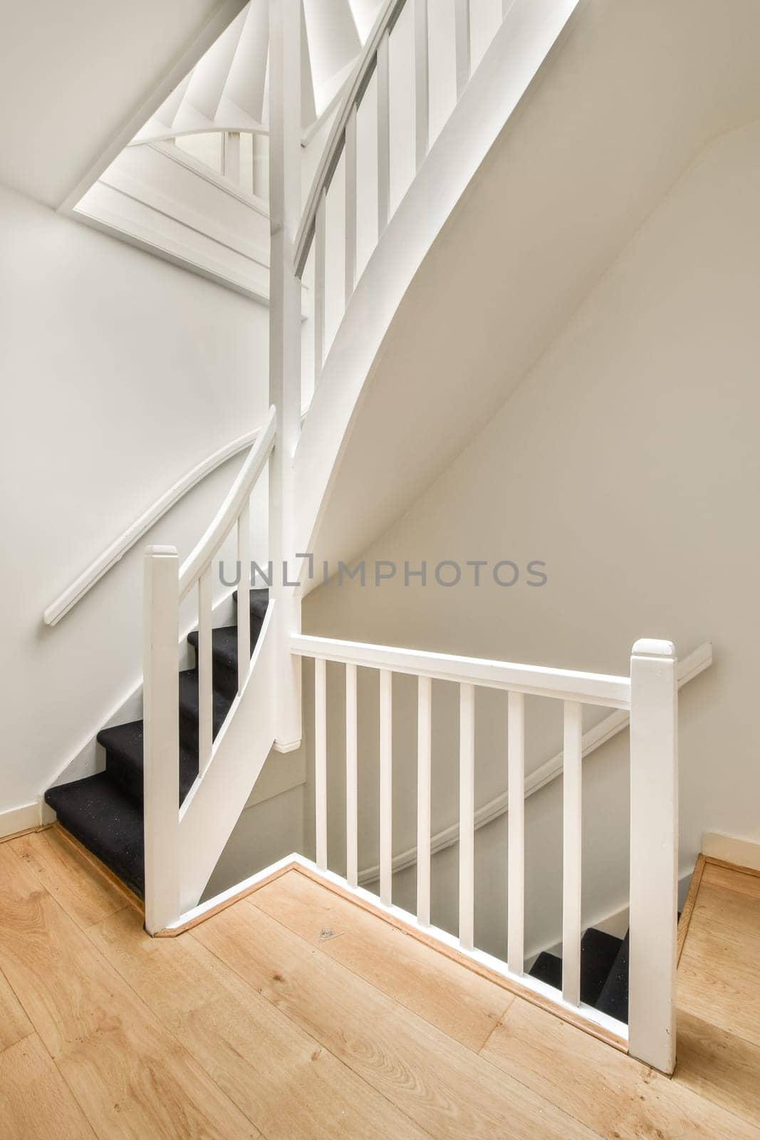 an empty room with stairs and a dog bed on the floor in front of the staircase leading up to the second floor