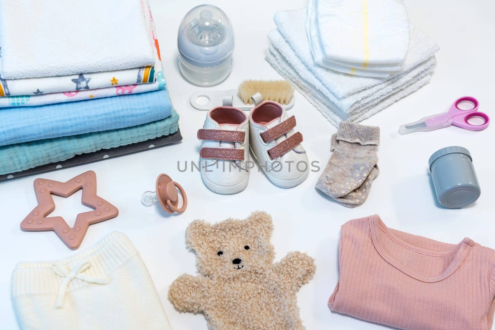 Set of baby shoes, toys and accessories on white background. Newborn stuff. Flat lay