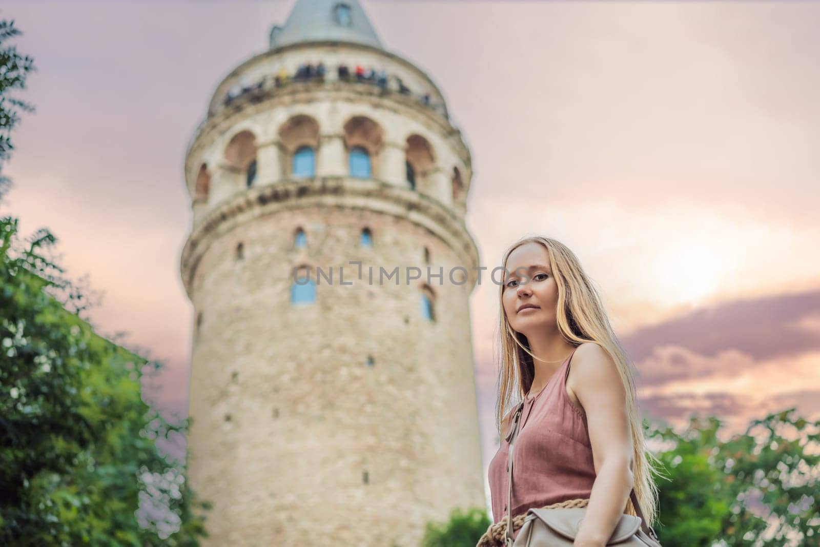 Portrait of beautiful woman tourist with view of Galata tower in Beyoglu, Istanbul, Turkey. Turkiye.