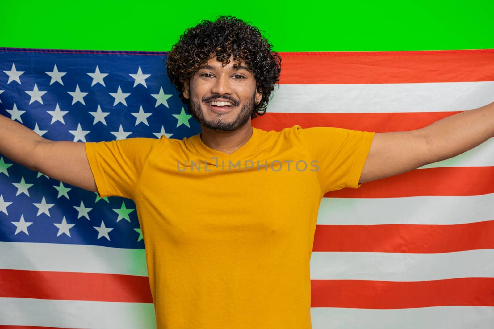 Young indian man waving and wrapping in American USA flag, celebrating, human rights and freedoms by efuror