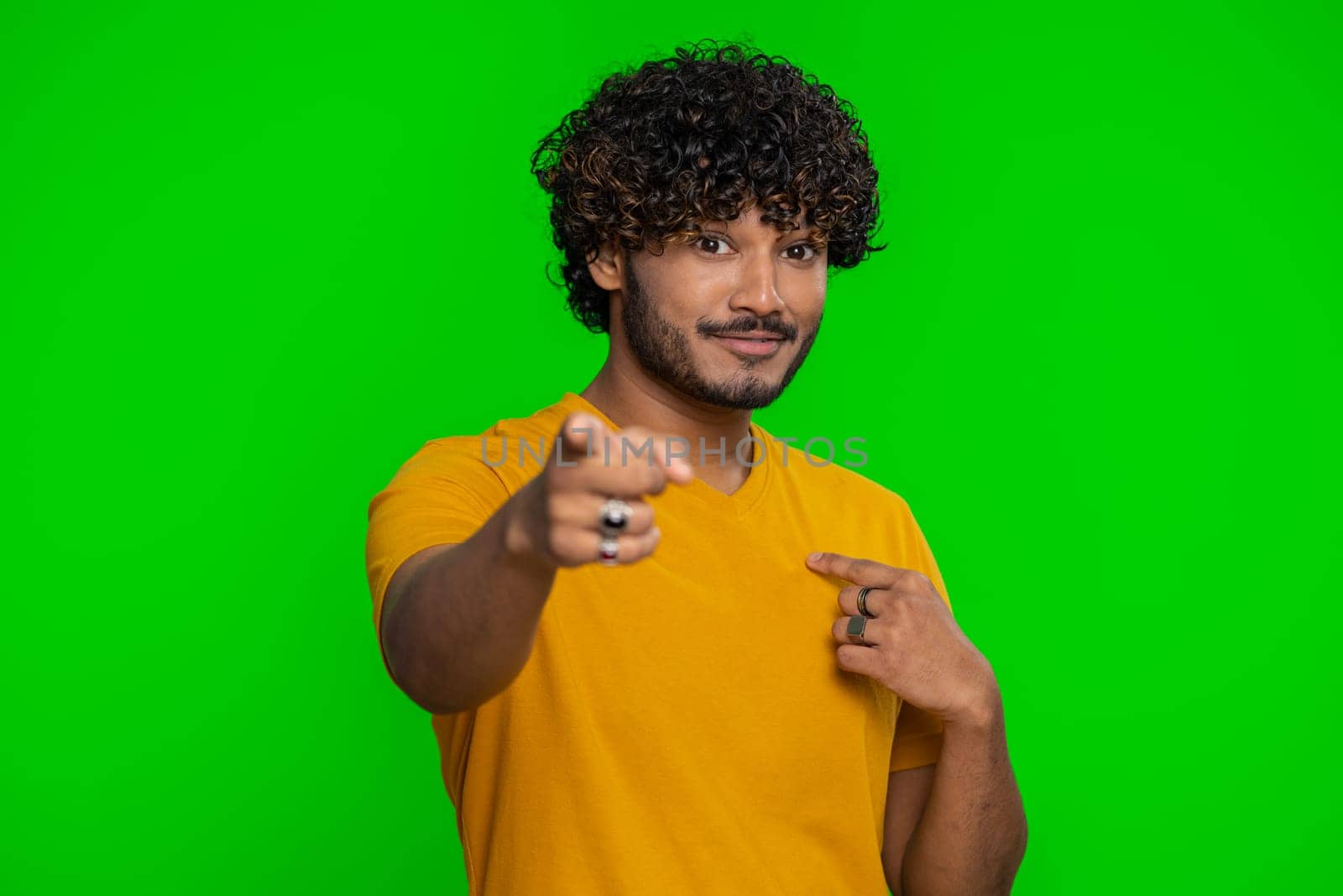 I choose you. Happy young indian man pointing to camera and looking with playful happy expression, making good choice, showing direction. Excited hindu guy isolated on green chroma key background