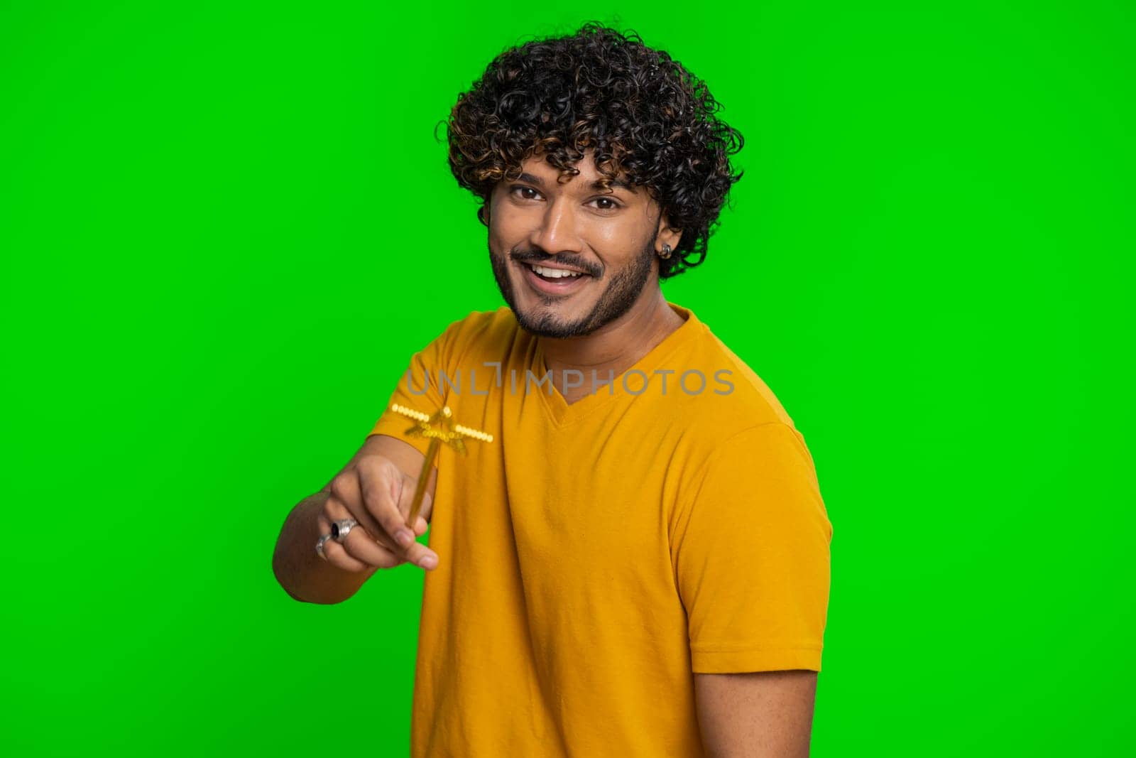 Magician wizard man gesturing with magic wand fairy stick, making wish come true, casting magician spell, advertising holidays sale discount. Handsome indian guy isolated on chroma key background