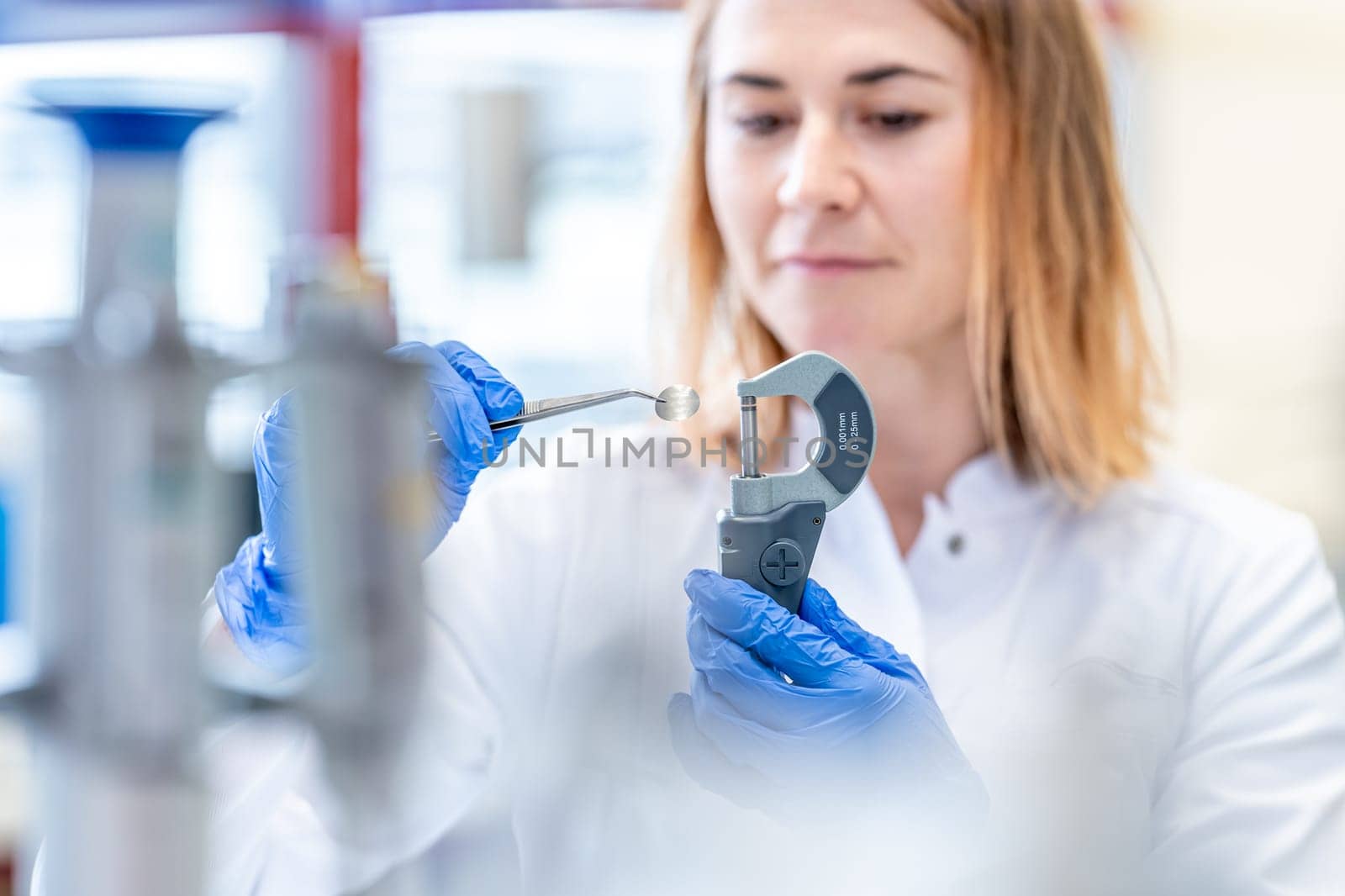 young woman scientist measures a sample in the laboratory by Edophoto