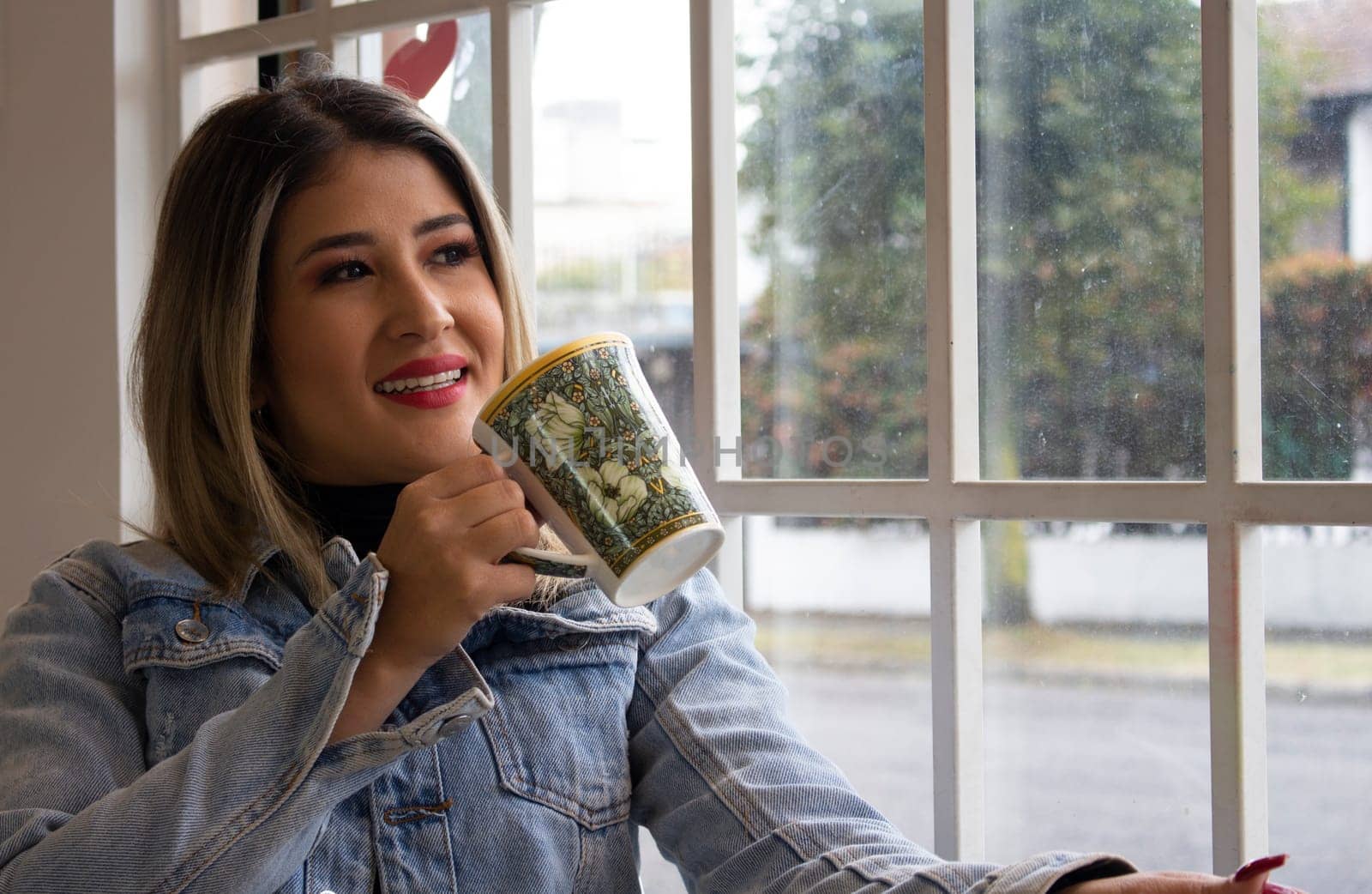 close-up of a businesswoman having a coffee and looking out the window. High quality photo