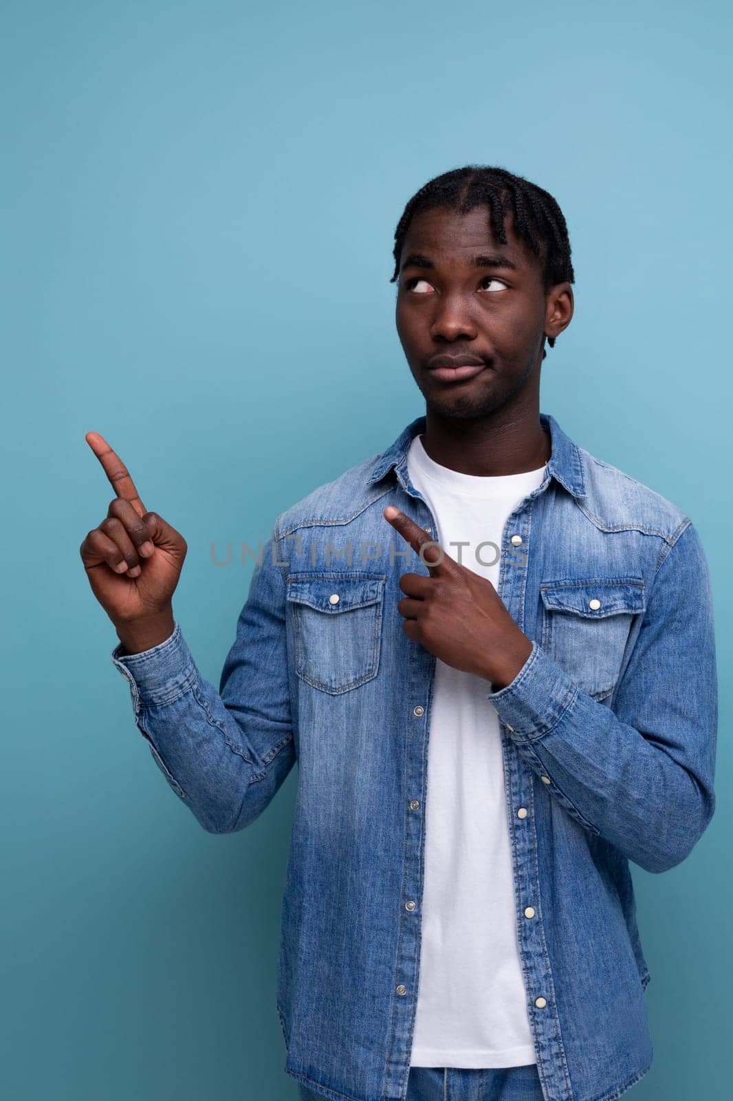 close-up portrait of a smart young stylish american guy with dreadlocks in a denim jacket with some kind of genius idea.