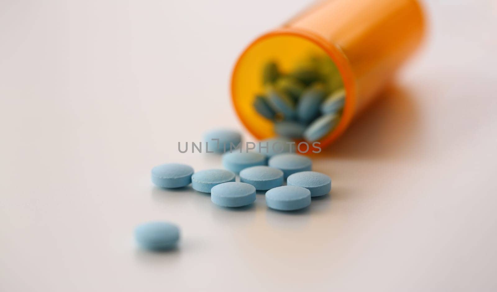 Medical round blue pills bottle with pills on table. Vitamins dietary supplements and medicines