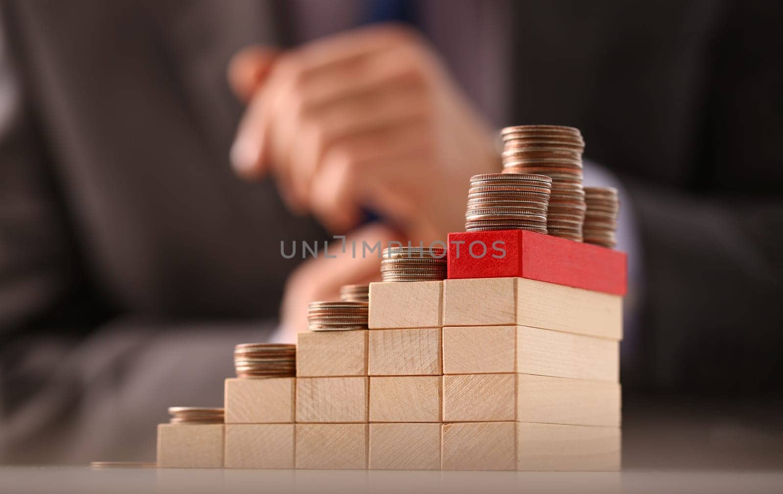 Wooden blocks with coins growing stacked and stacked in increasing piles. Investment growth and financial profit concept