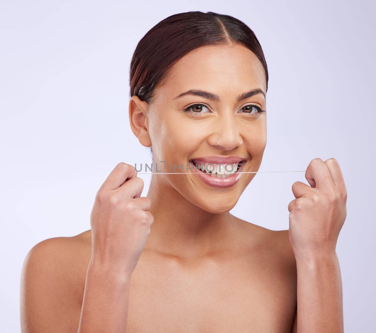 Portrait, happy and woman flossing teeth on studio background for healthy dental wellness. Female model, oral thread and cleaning mouth of fresh breath, tooth maintenance and care of smile for beauty by YuriArcurs