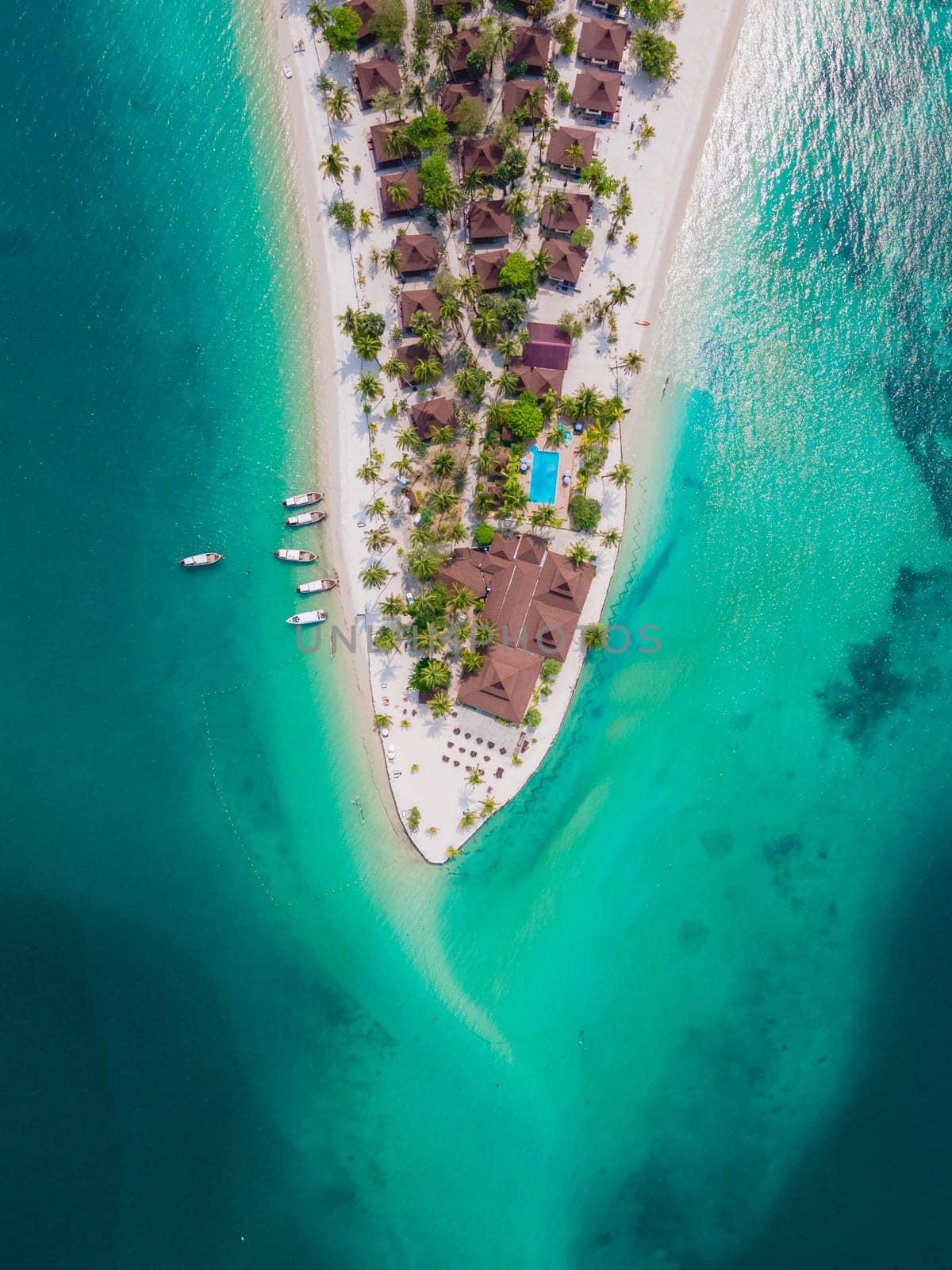 Koh Mook tropical Island in the Andaman Sea in Thailand, tropical beach with white sand and turqouse colored ocean with coconut palm trees. wooden bungalows on the beach