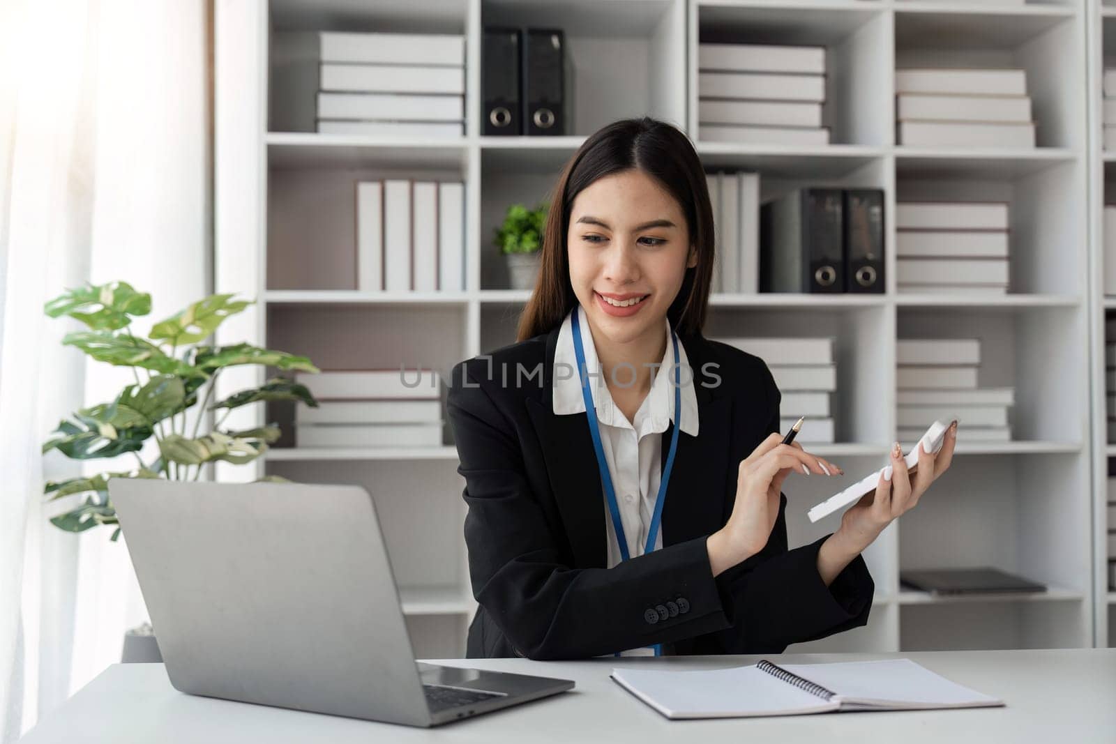 Business woman using calculator for do calculate finance on desk in office and working tax, accounting, statistics and analytic research concept.