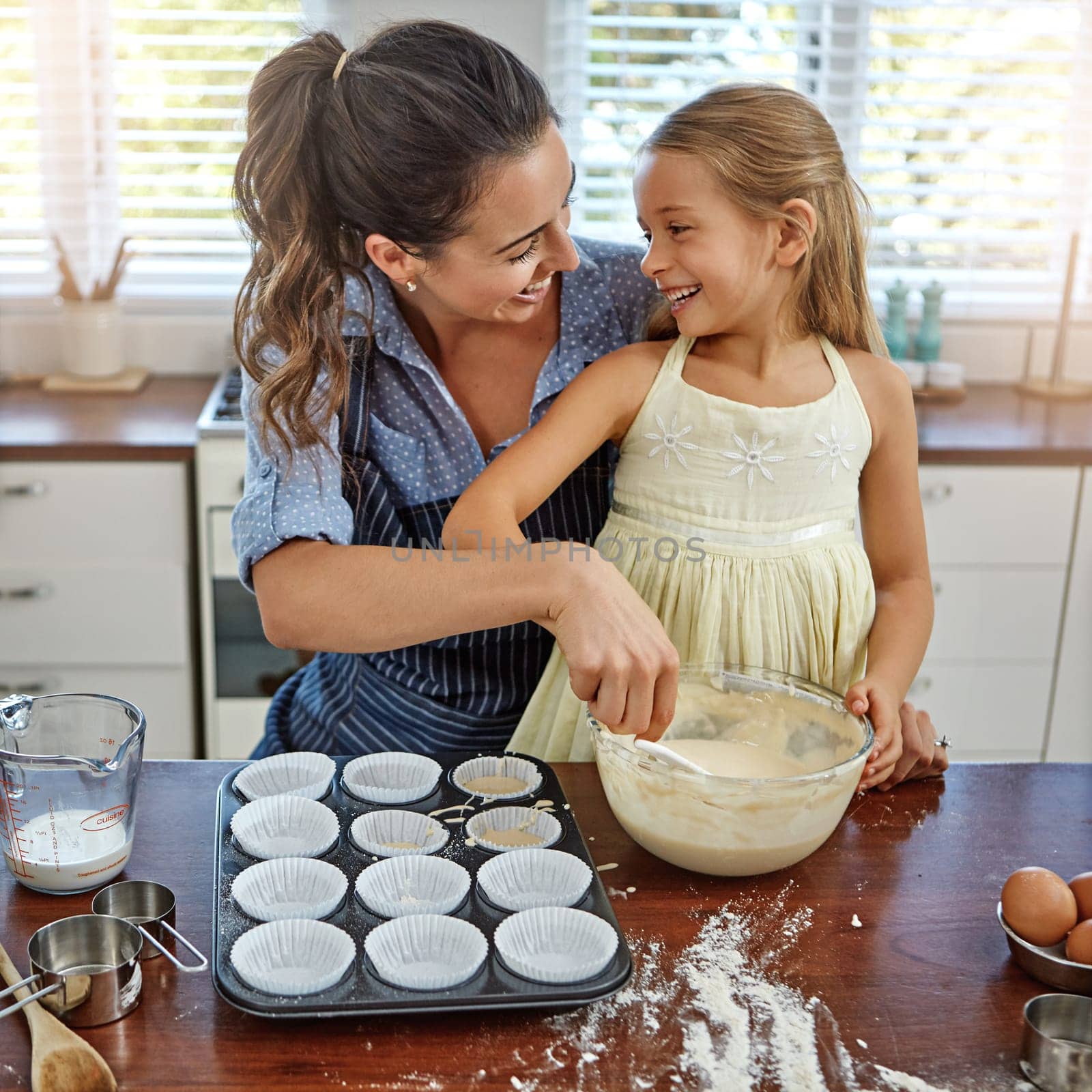 My favorite thing to do is bake with my mom. a mother and her daughter baking in the kitchen