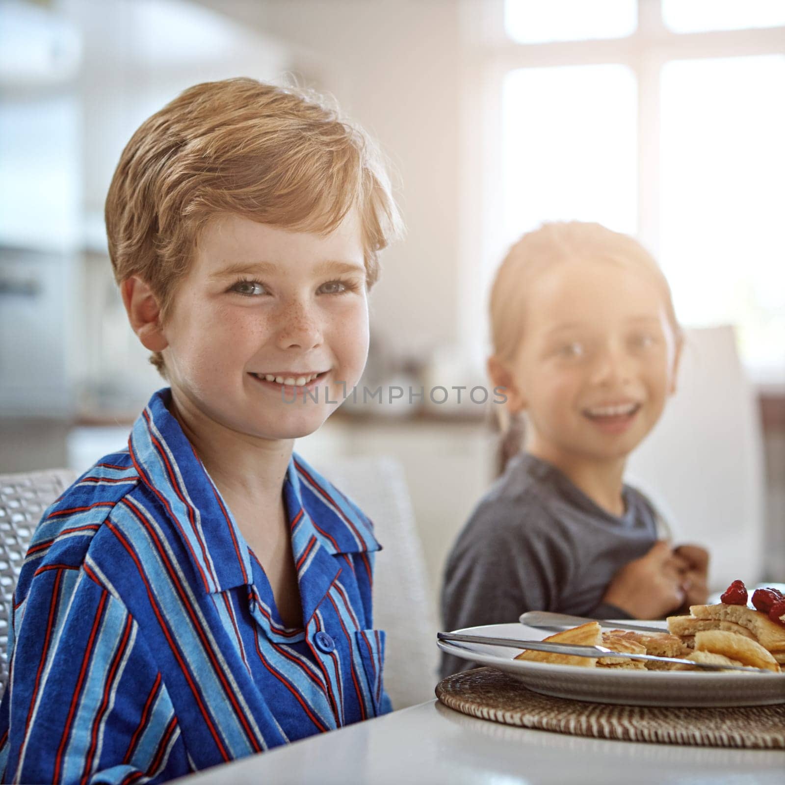 Breakfast fuels you up. a sister and brother having breakfast