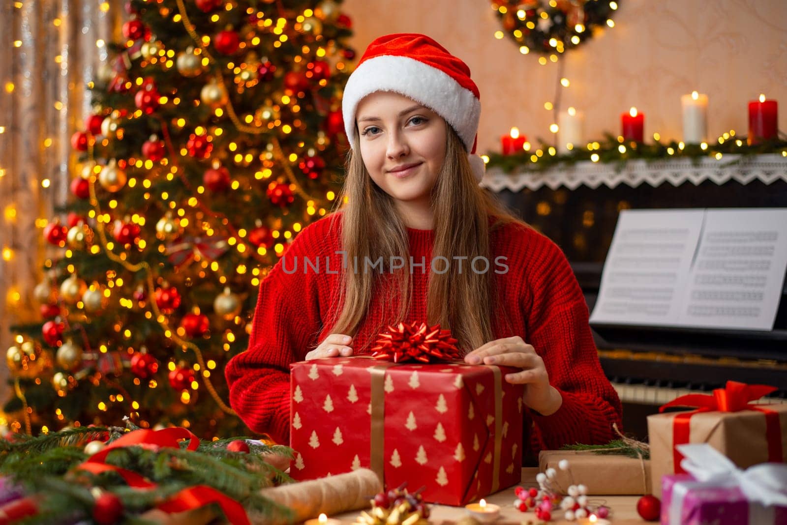 Cheerful girl with big red gift box sitting in a wonderfully decorated room