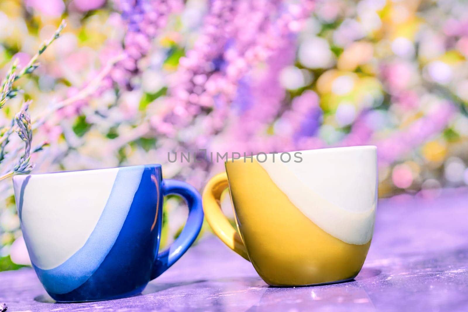 Coffee time.Break,pause and relax. Yellow and blue coffee tea cups on pink floral background. High quality photo