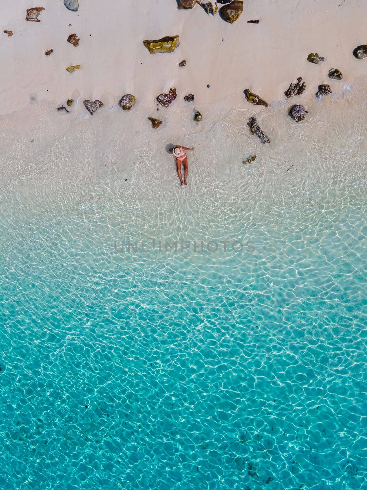 a women swimming in the ocean of of Koh Kradan Island in Thailand by fokkebok