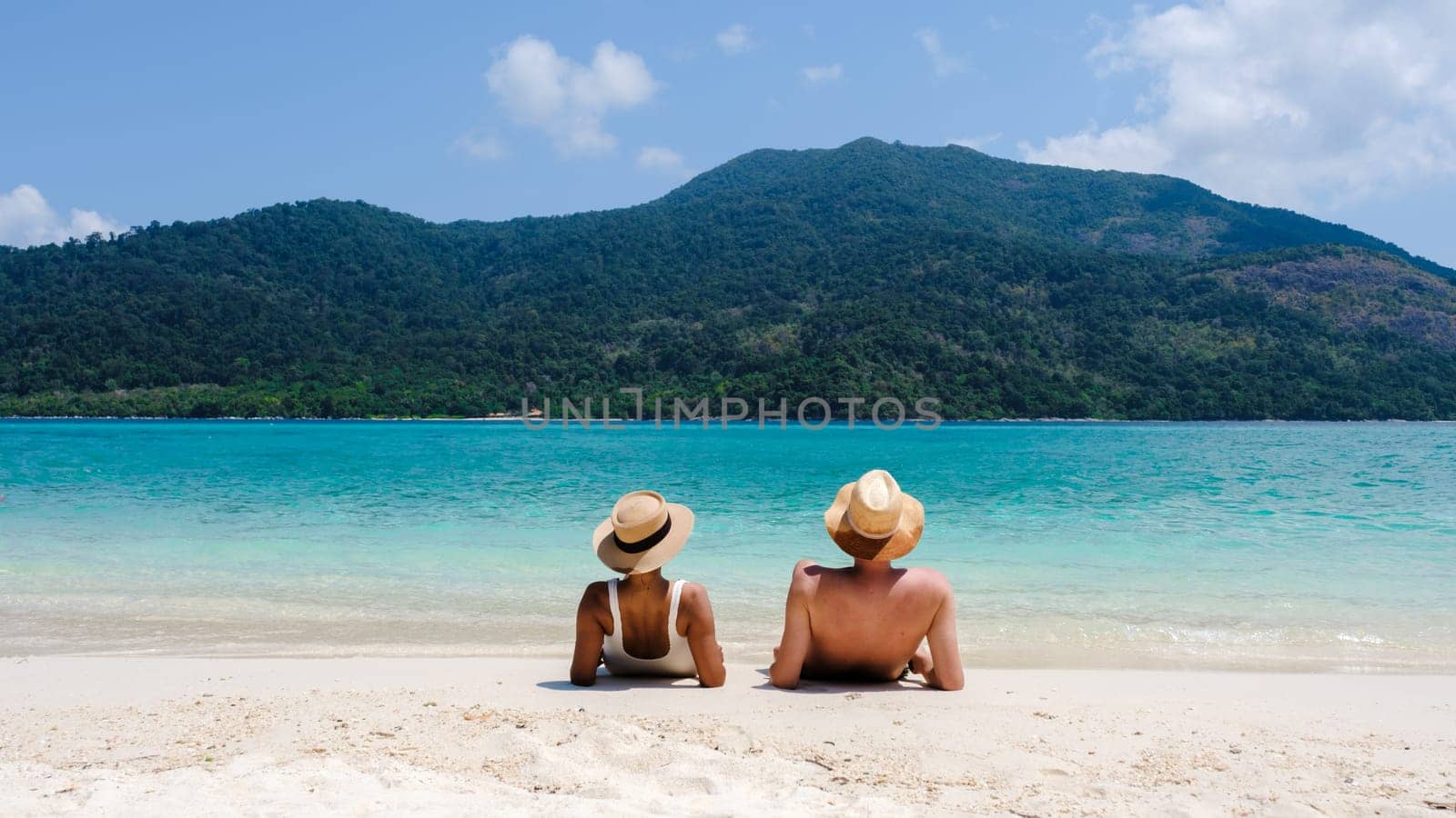 Couple on the beach of Koh Lipe Island Thailand, a tropical Island with a blue ocean and white soft sand. Ko Lipe Island Thailand