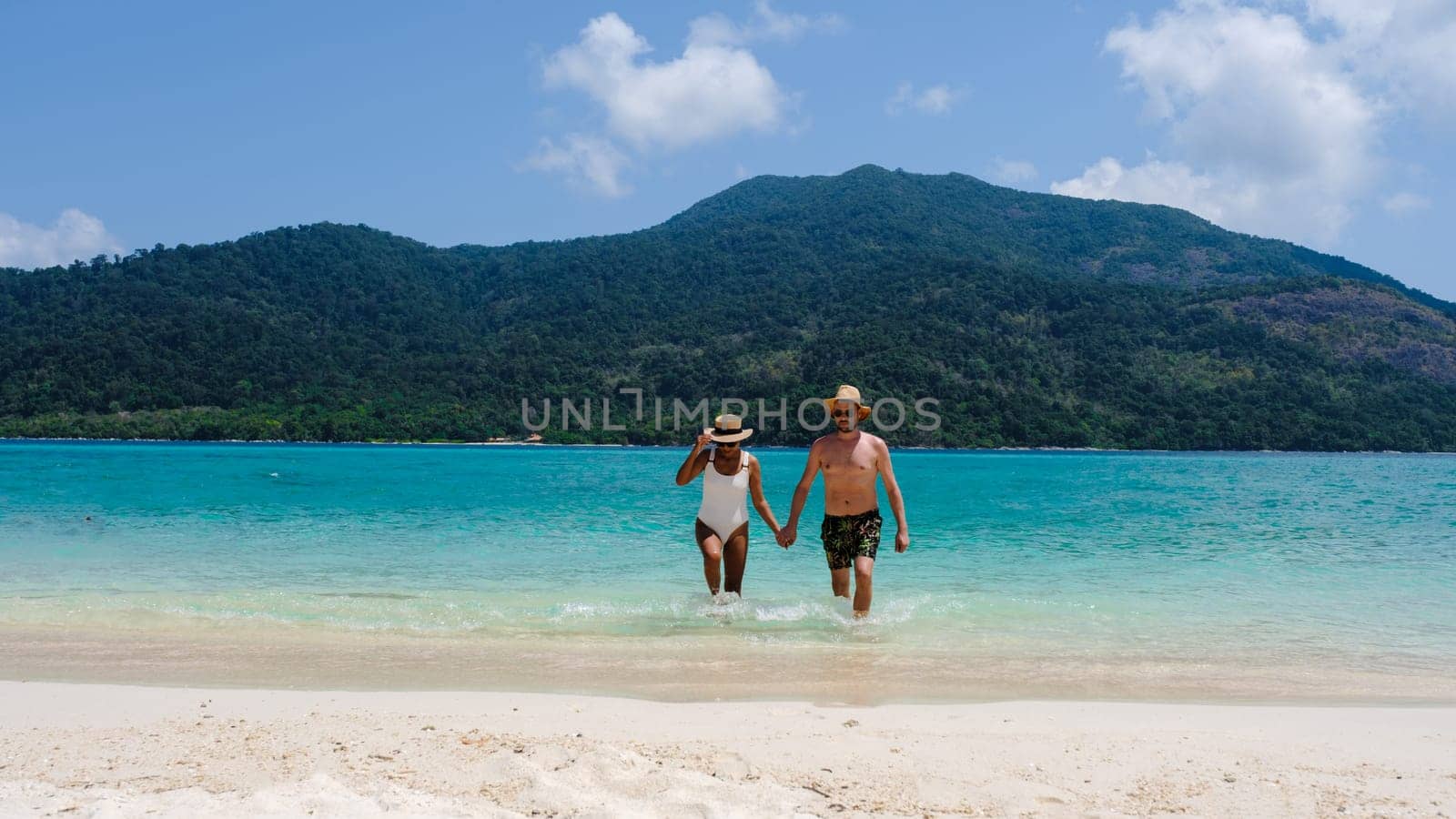 Couple on the beach of Koh Lipe Island Thailand, a tropical Island with a blue ocean and white soft sand. Ko Lipe Island Thailand