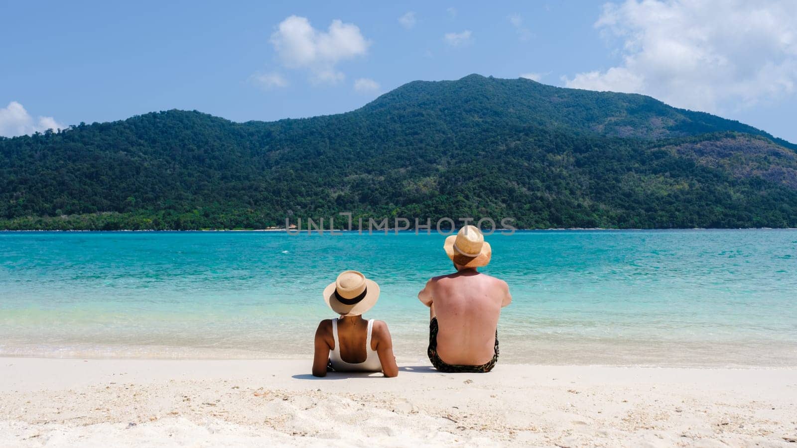 Couple of men and women on the beach of Koh Lipe Island Thailand, a tropical Island with a blue ocean and white soft sand. Ko Lipe Island Thailand