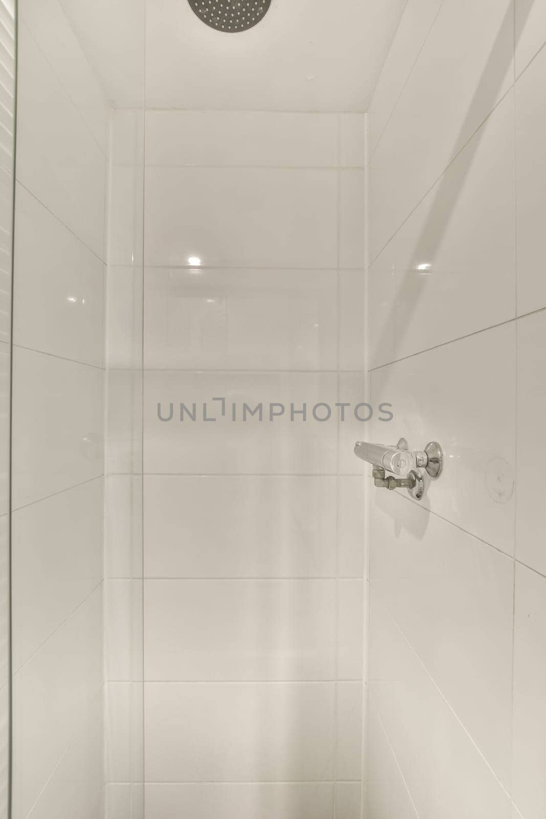 a white shower in a bathroom with a glass door by casamedia