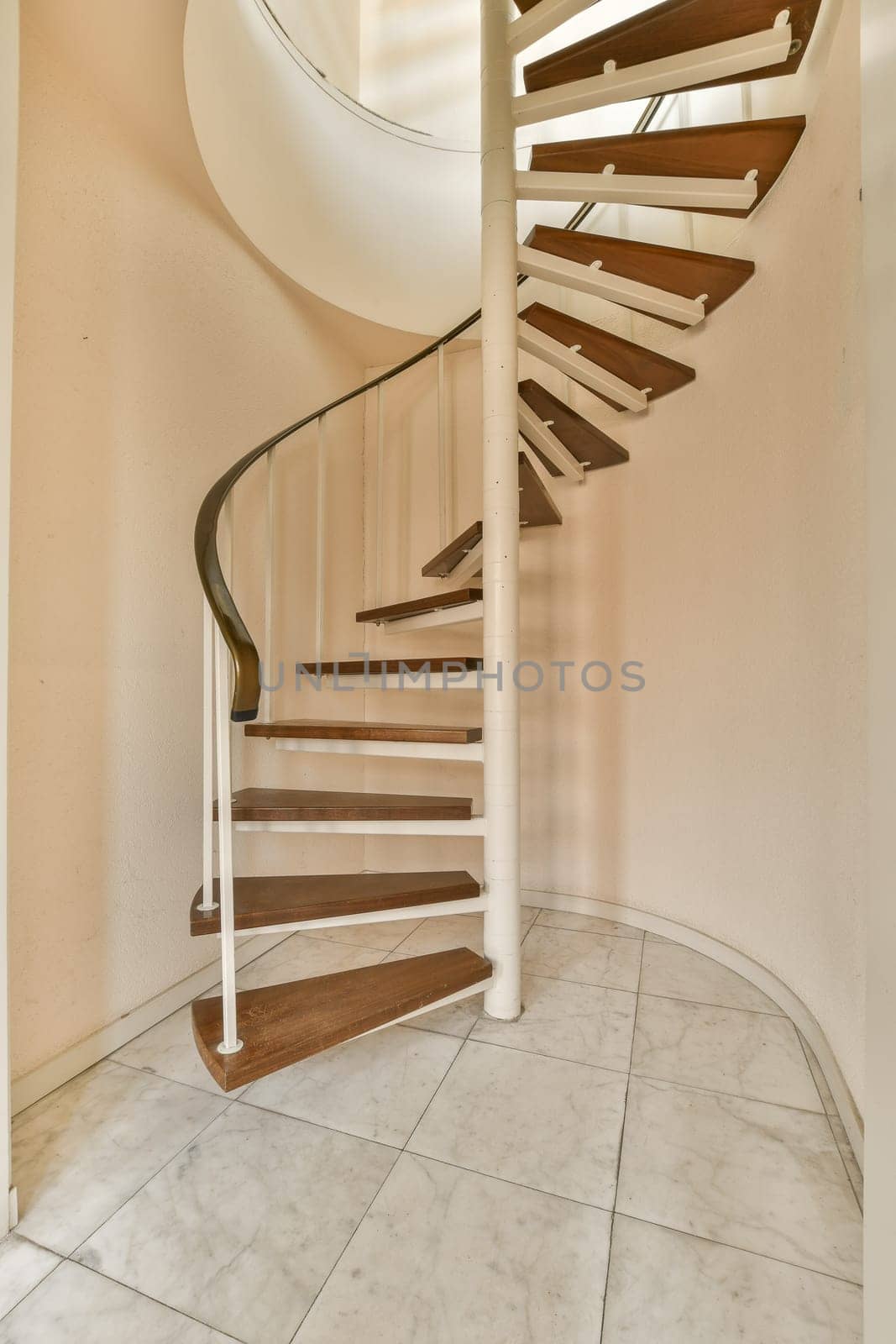 a spiral staircase in an empty room with white walls and marble flooring on either side, the stairs are made of wood