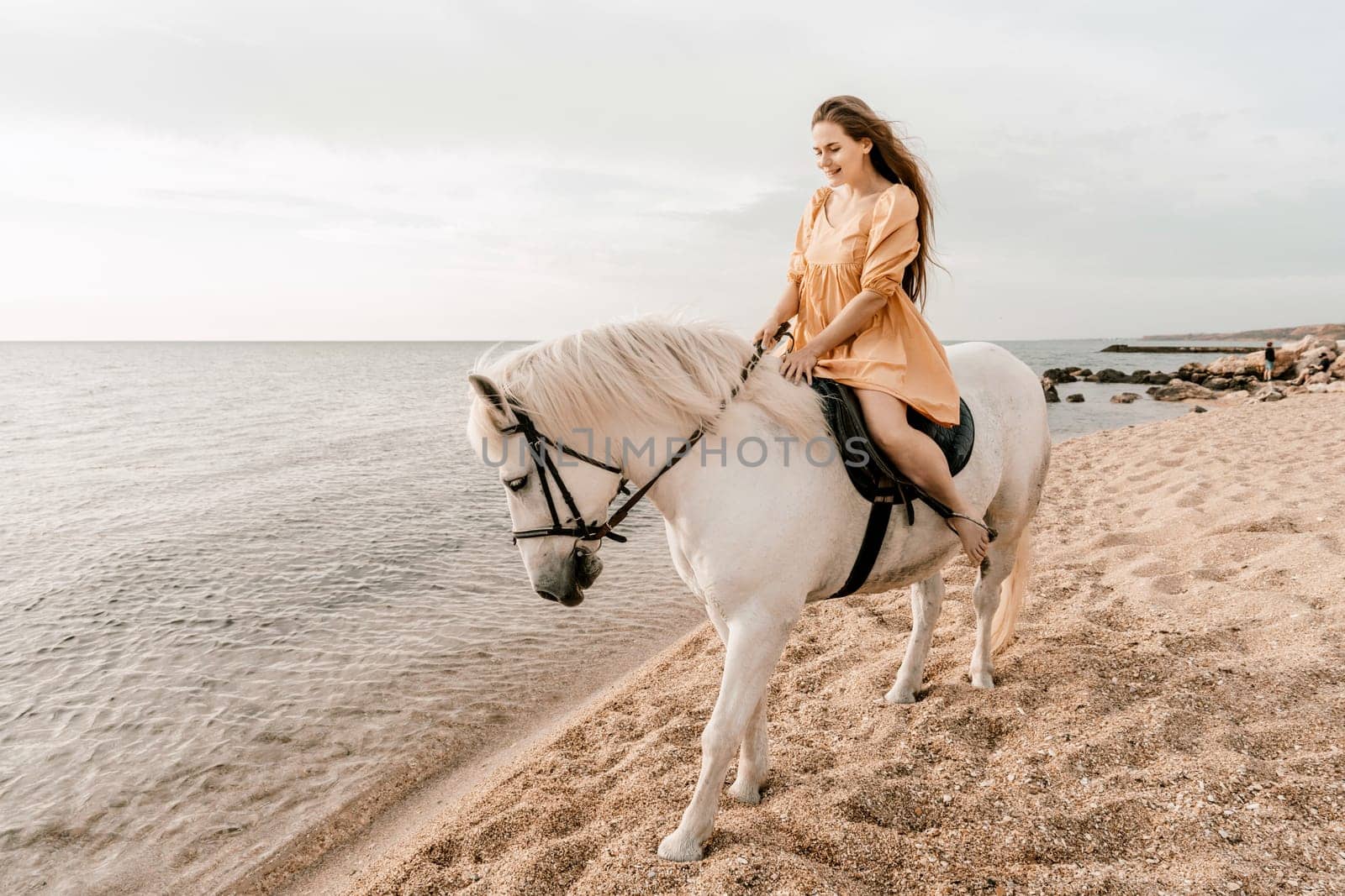 Happy woman and a white horse against the background of the sky and the sea. by Matiunina