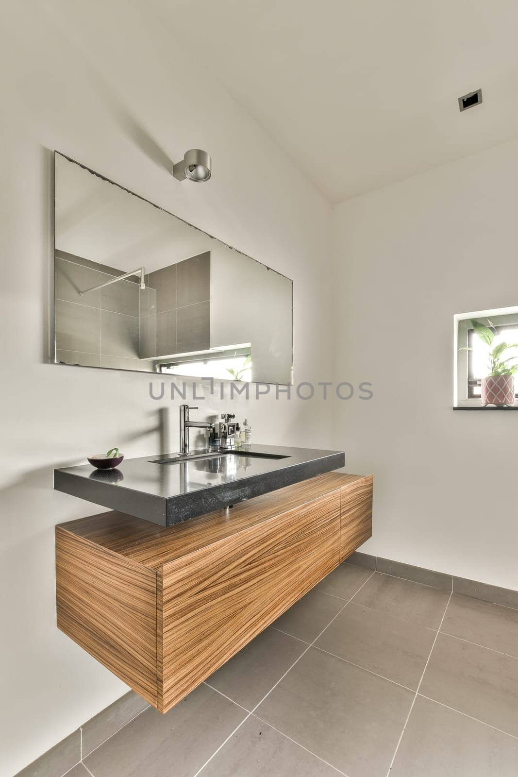 a modern bathroom with a sink and a mirror by casamedia