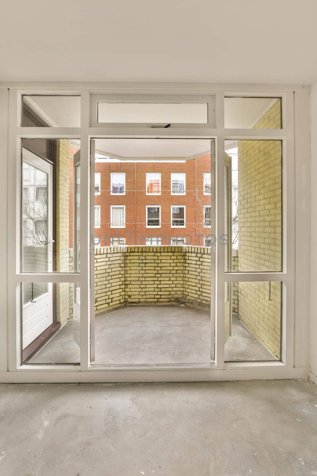 a room with a large window and a brick building by casamedia