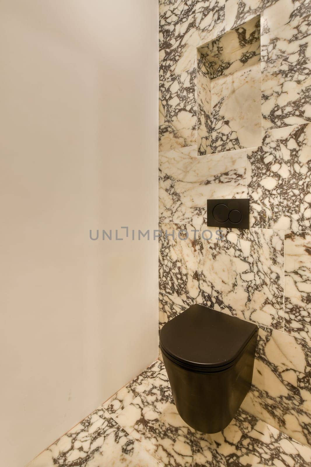 a bathroom with a black toilet and a marble wall by casamedia