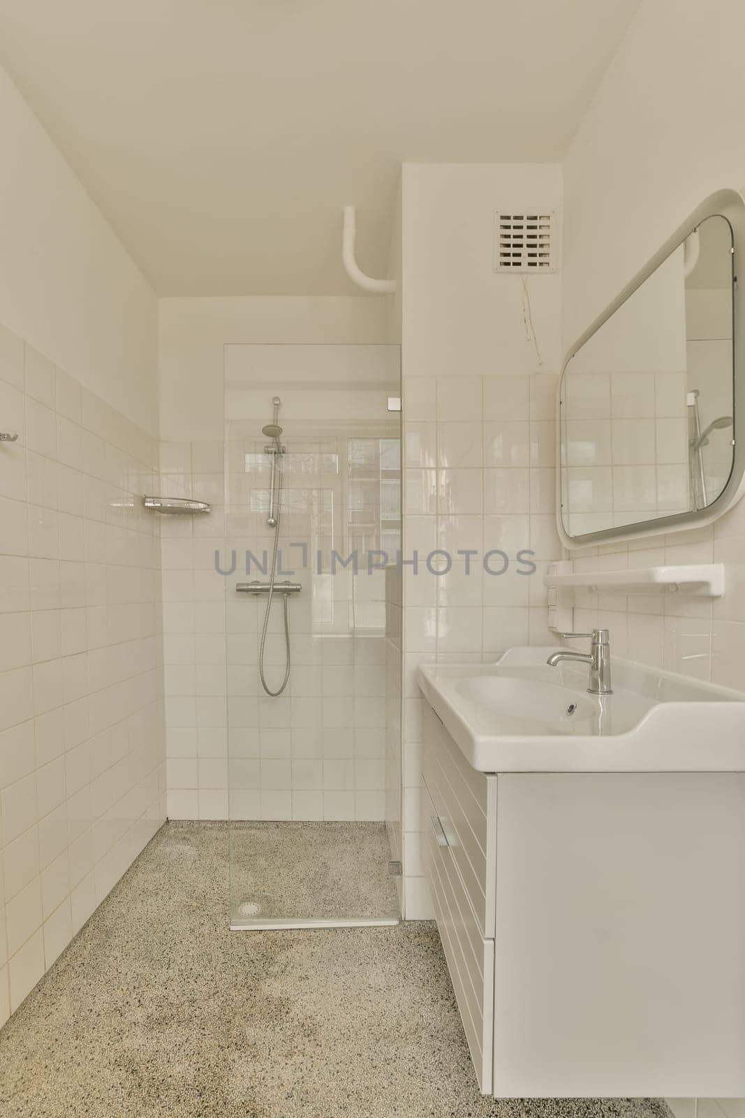 a bathroom with a sink, mirror and shower head mounted on the wall in it's corner to the left